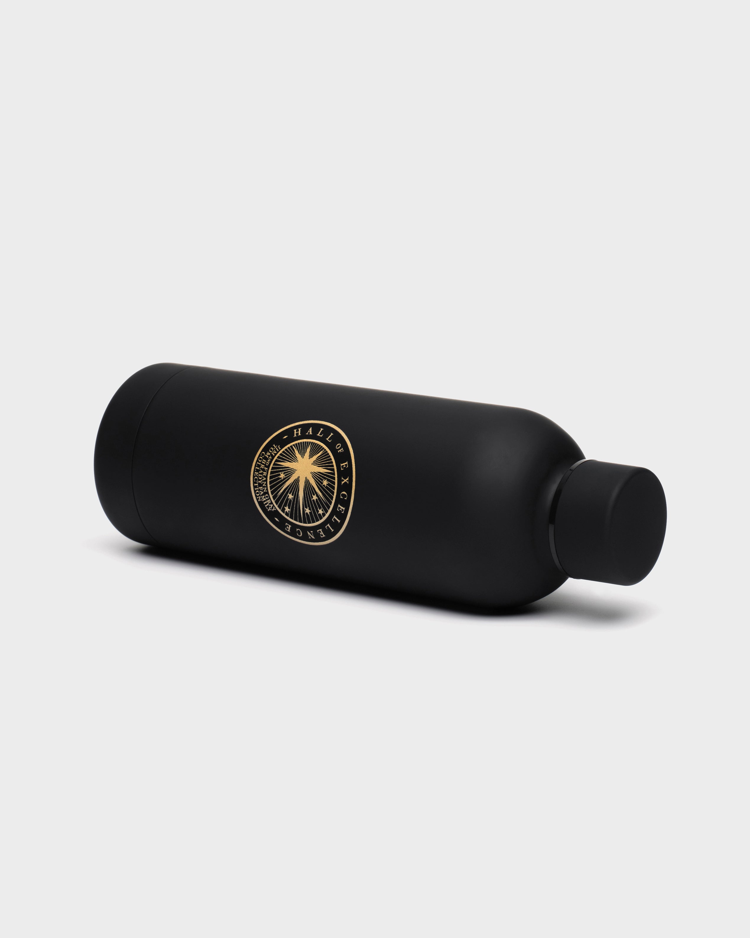Black cylindrical bottle with a gold Hall of Excellence logo on a light gray background