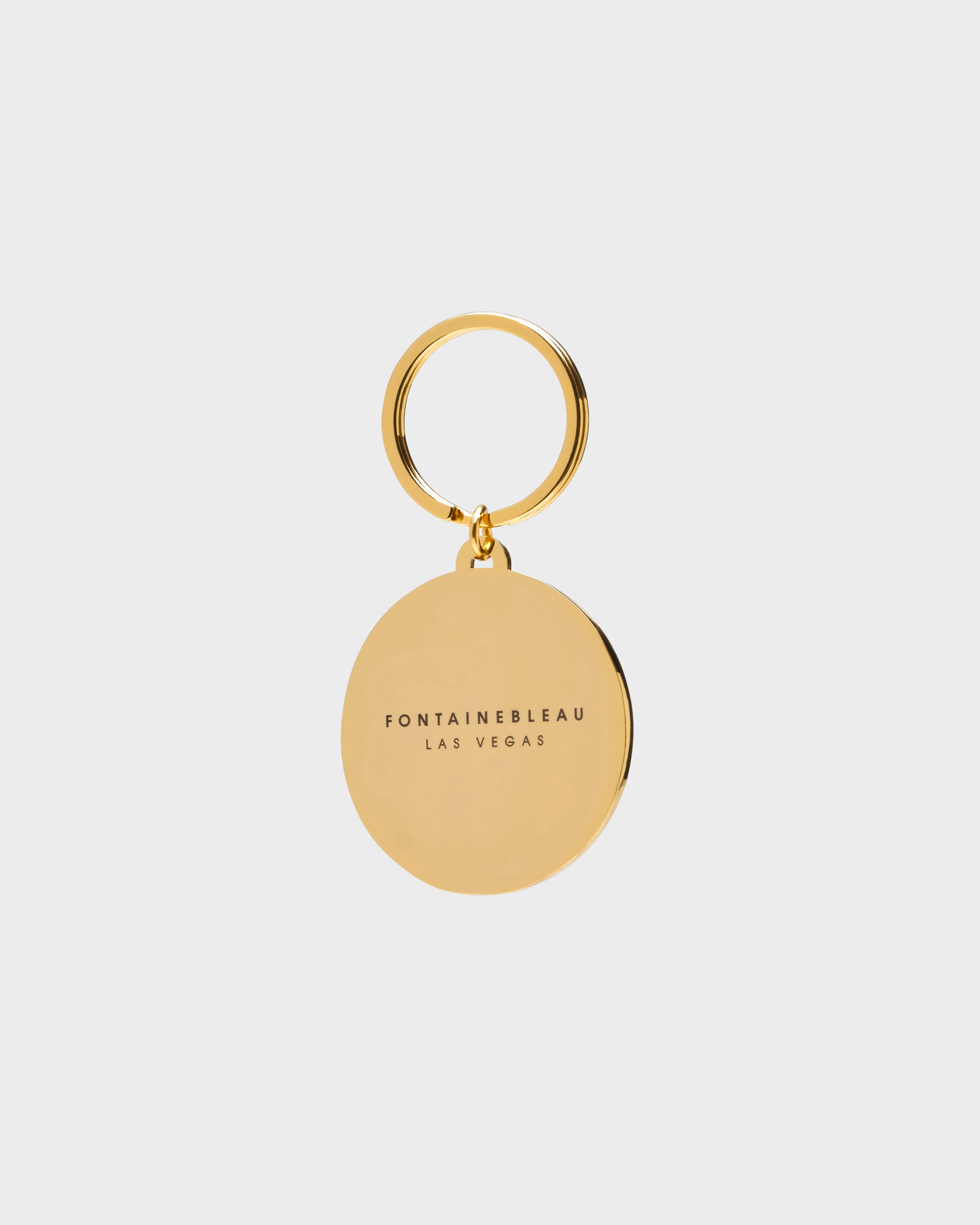 Gold keychain with 'Fontainerbleau Las Vegas' text on a light gray background