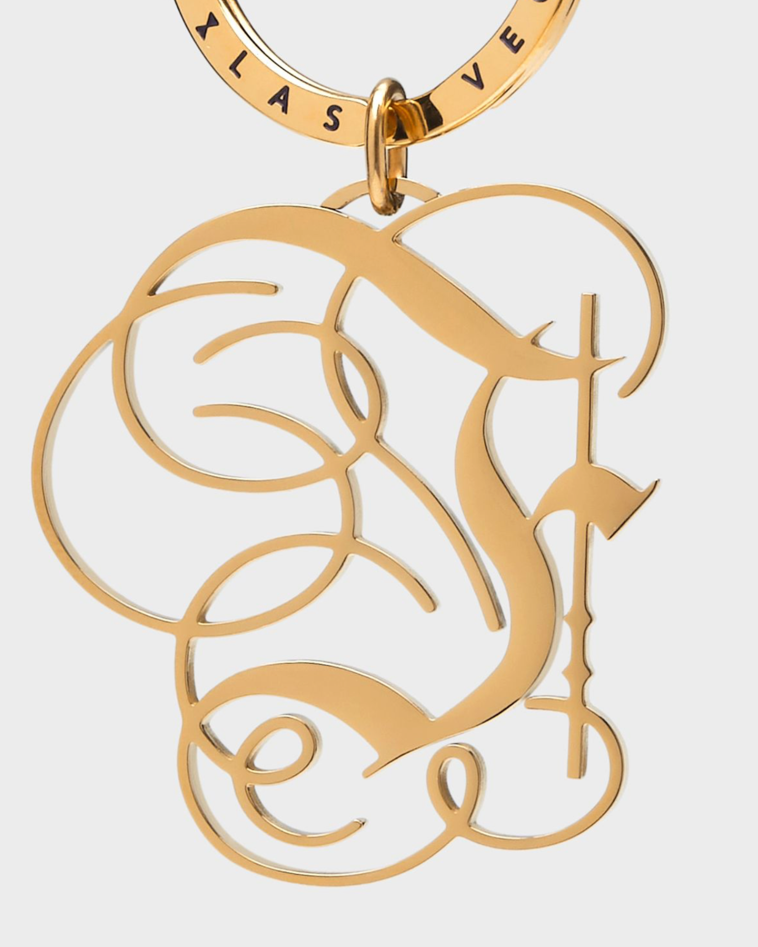 Gold keychain with intricate design on a white background